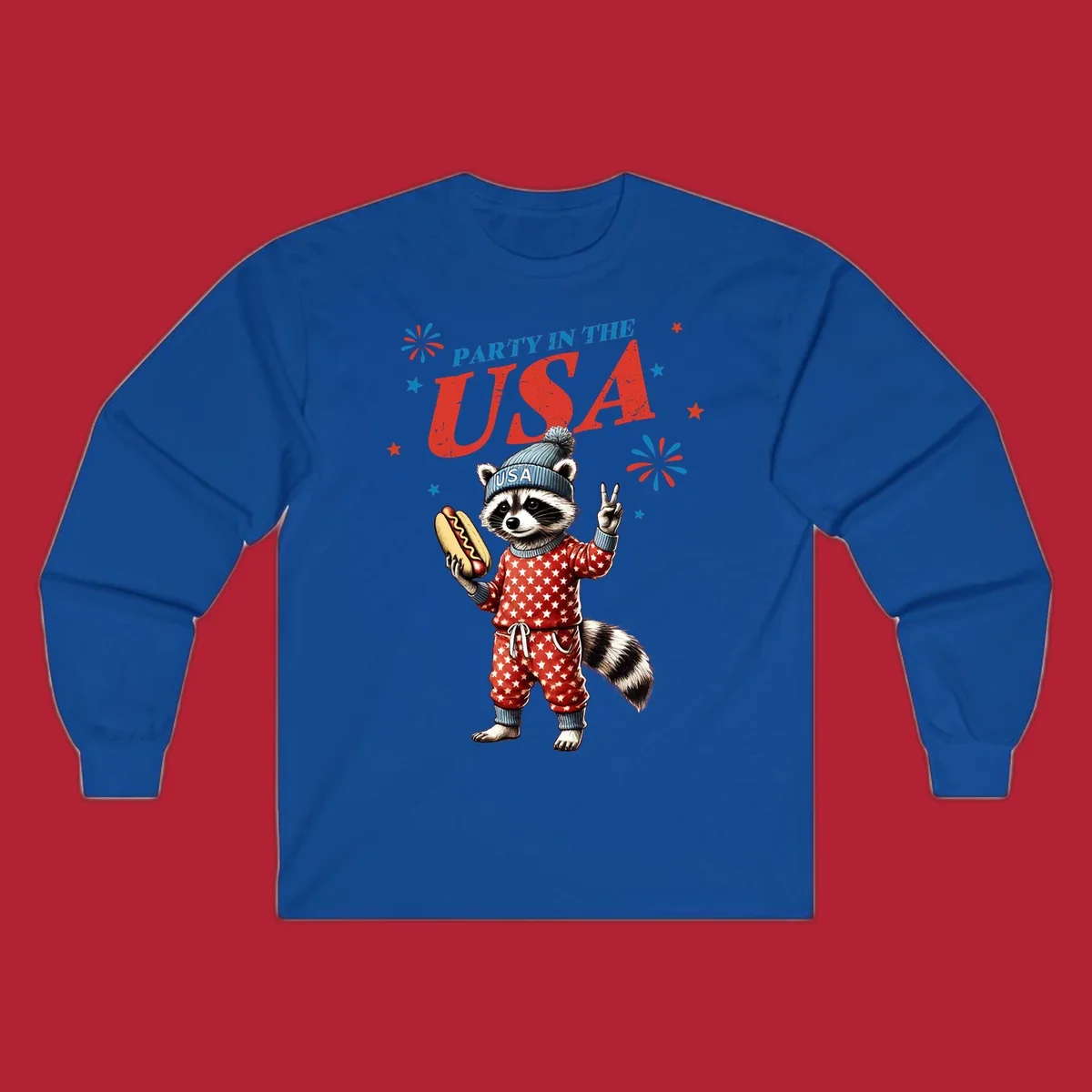 A cartoon raccoon wearing a USA beanie and star-patterned pajamas, holding a hotdog and making a peace sign, with 'PARTY IN THE USA' text and fireworks.
