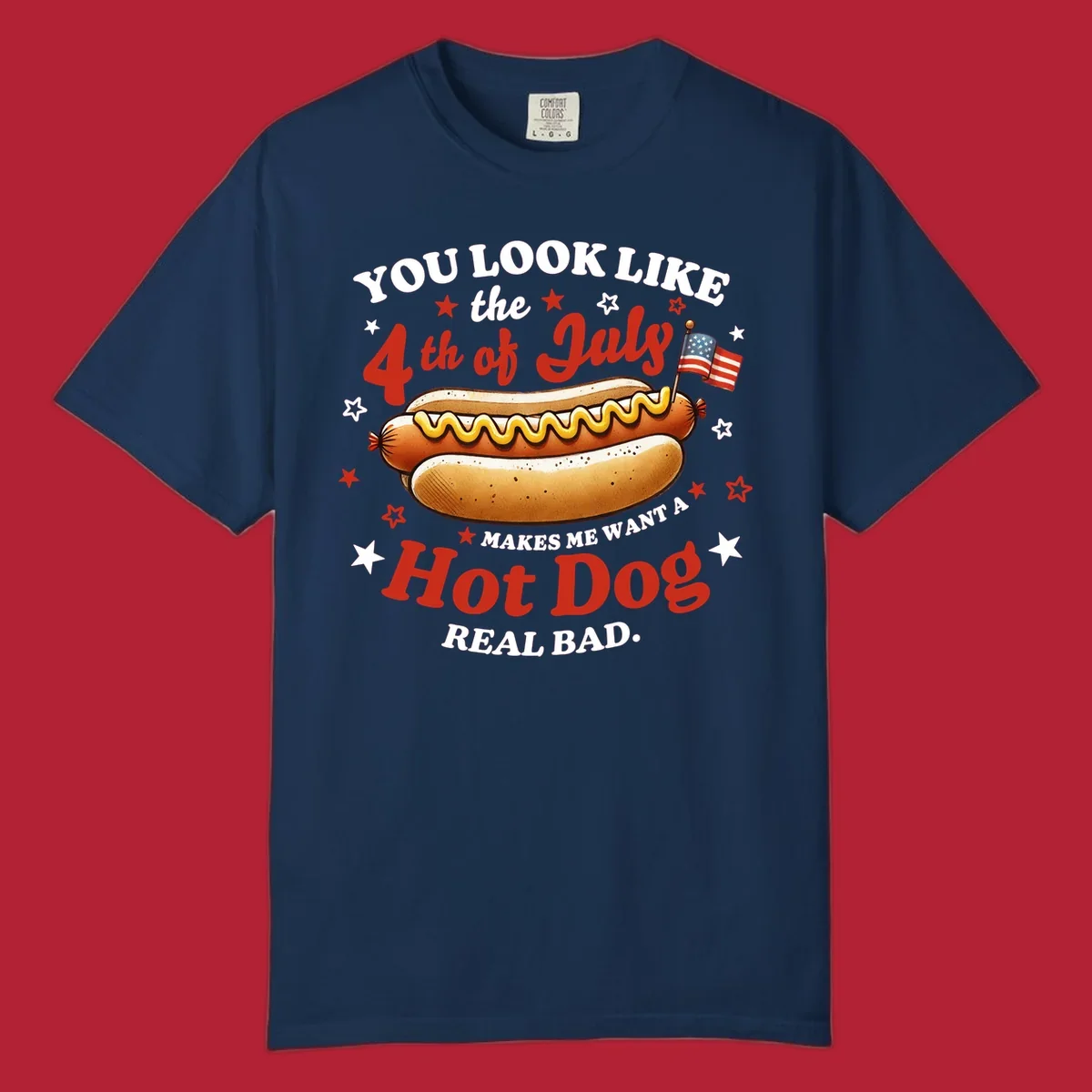 An illustrated hot dog with mustard, American flags, and stars. Text reads "YOU LOOK LIKE the 4th of July MAKES ME WANT A Hot Dog REAL BAD." you-look-like-4th-july design.