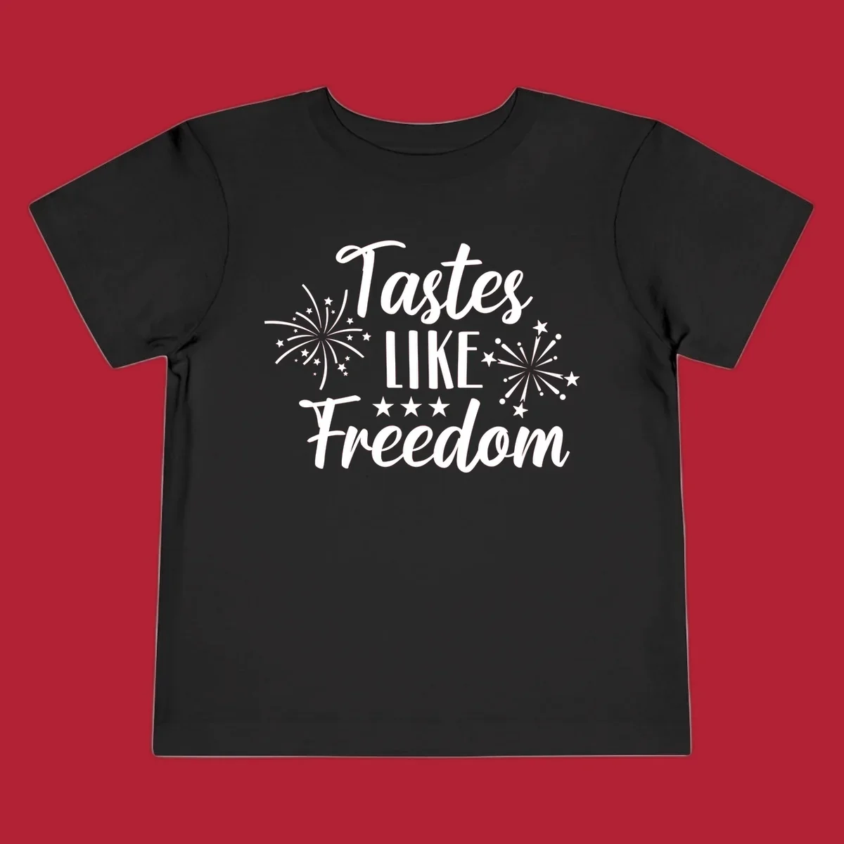 A patriotic design with the phrase 'Tastes LIKE Freedom' in script and block letters, surrounded by fireworks and stars.