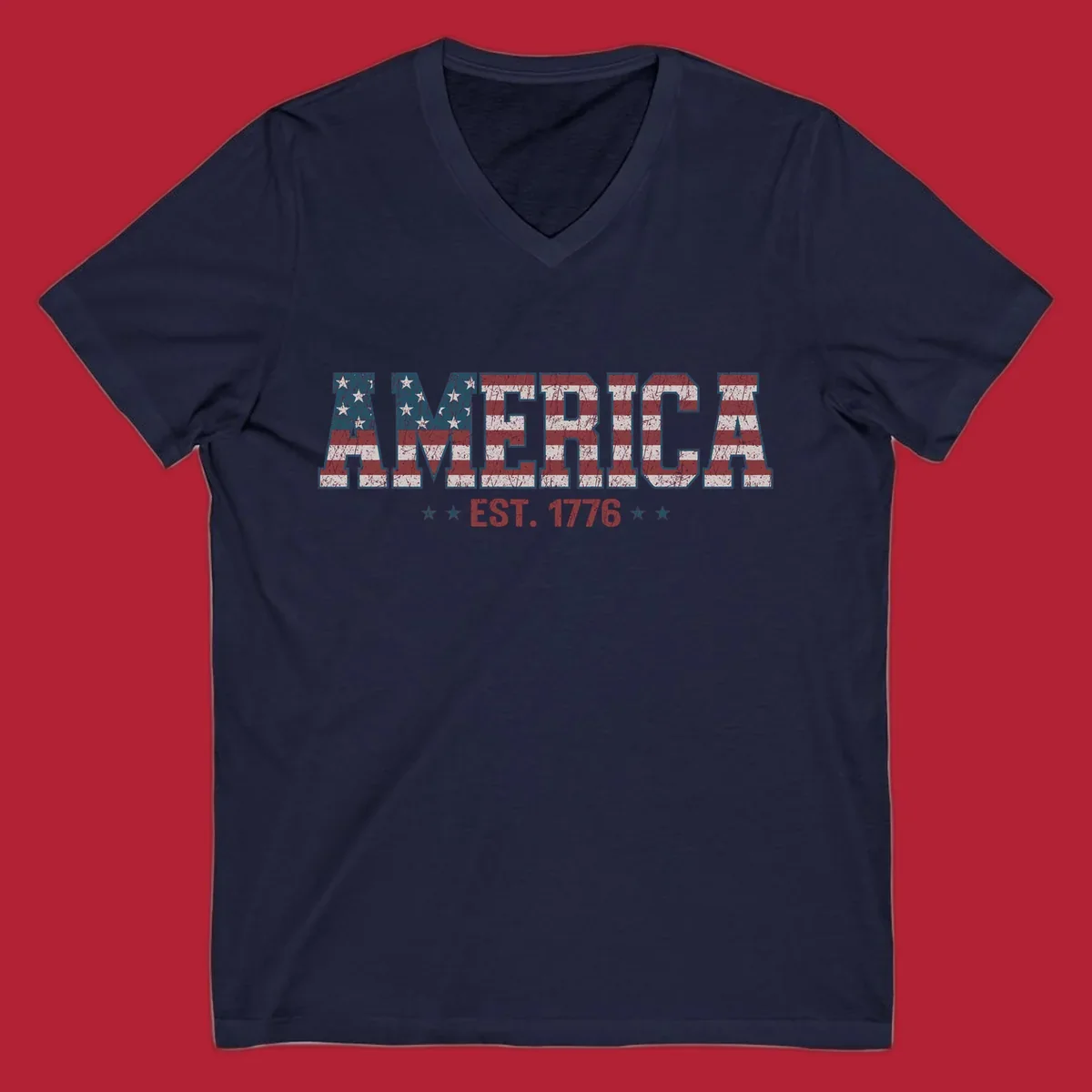 Distressed America Est. 1776 flag design with red, white, and blue flag pattern on block letters and stars.