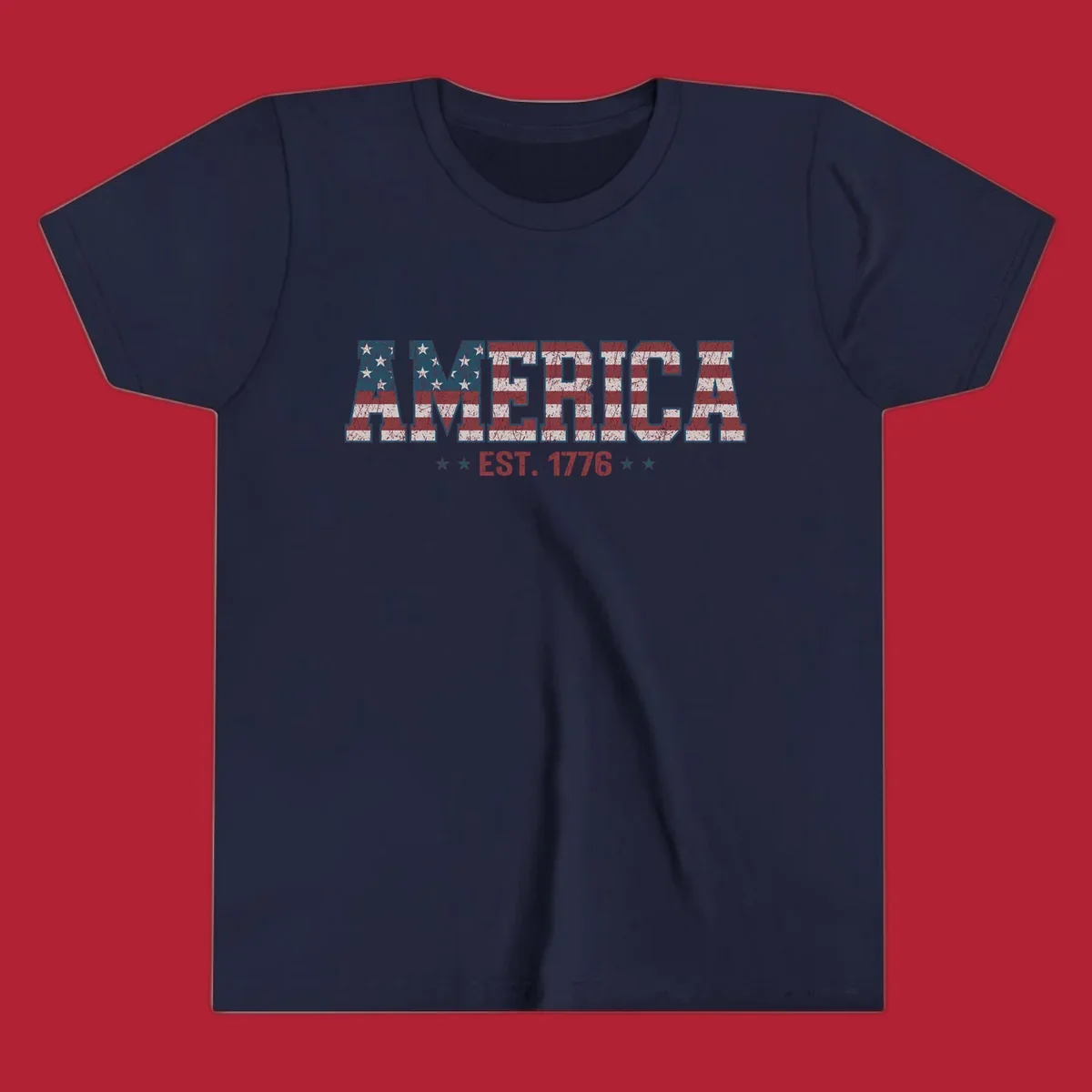 Distressed America Est. 1776 flag design with red, white, and blue flag pattern on block letters and stars.