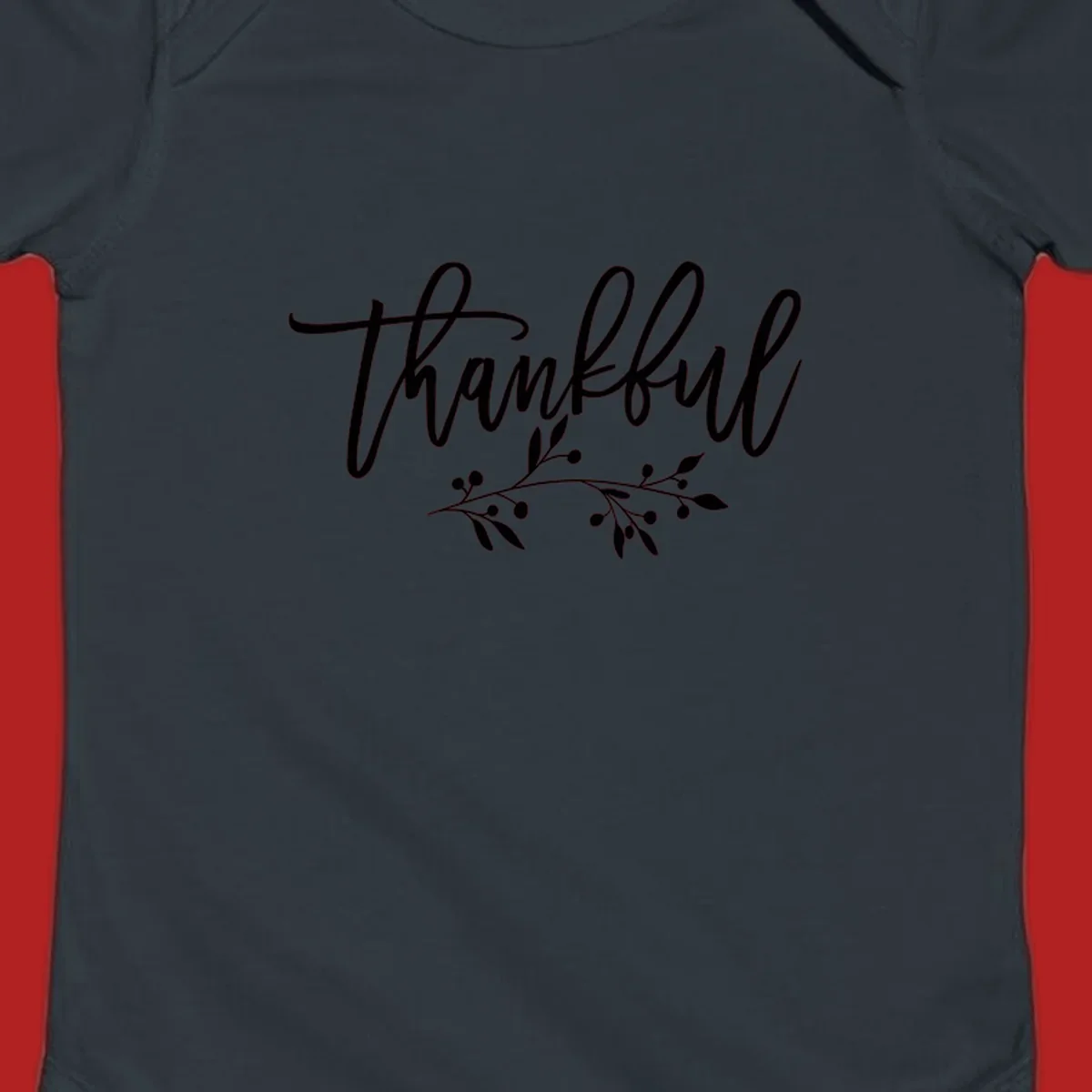 Elegant script text 'Thankful' with a small botanical branch accent, on a plain background.