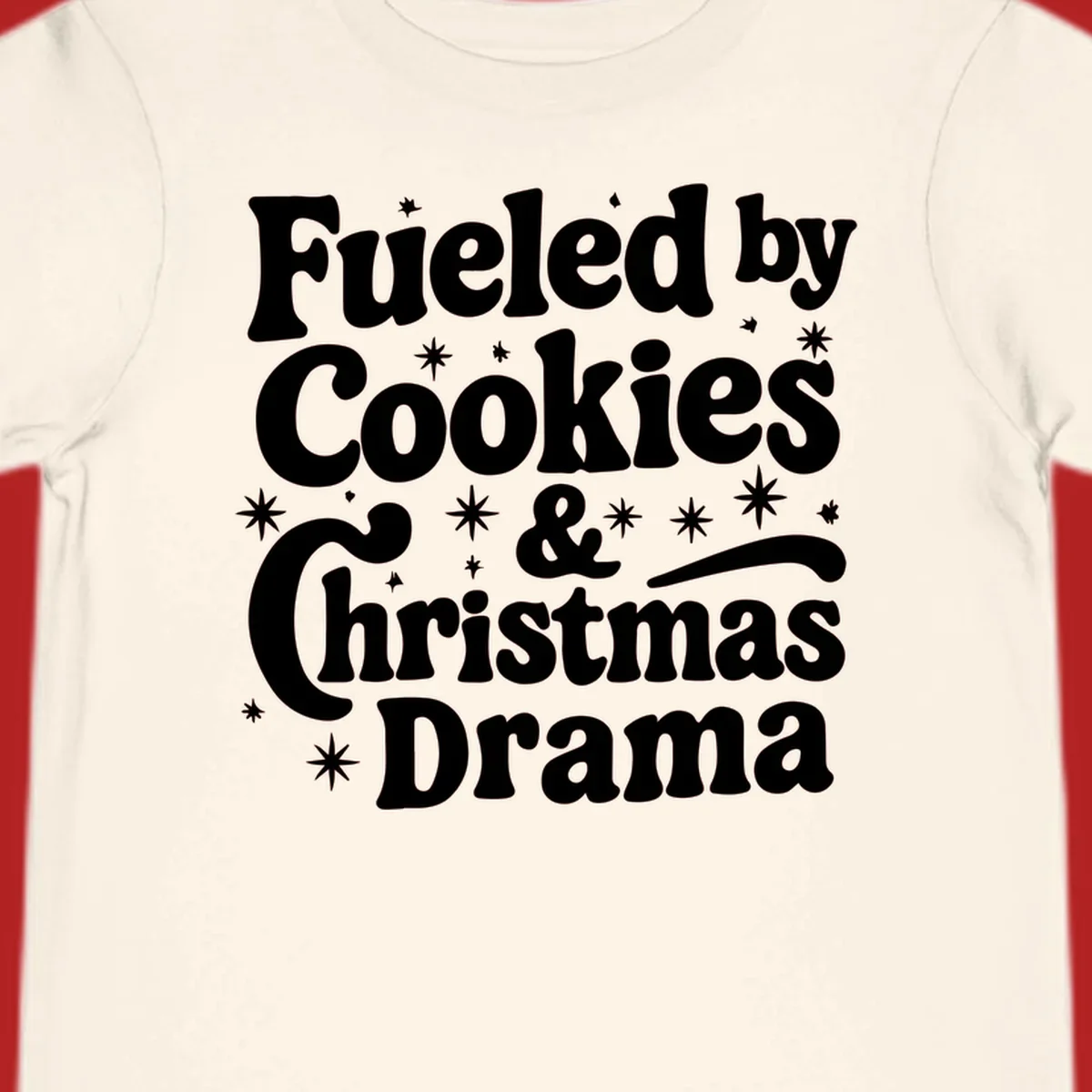 Text design 'Fueled by Cookies & Christmas Drama' with stars, for Christmas.