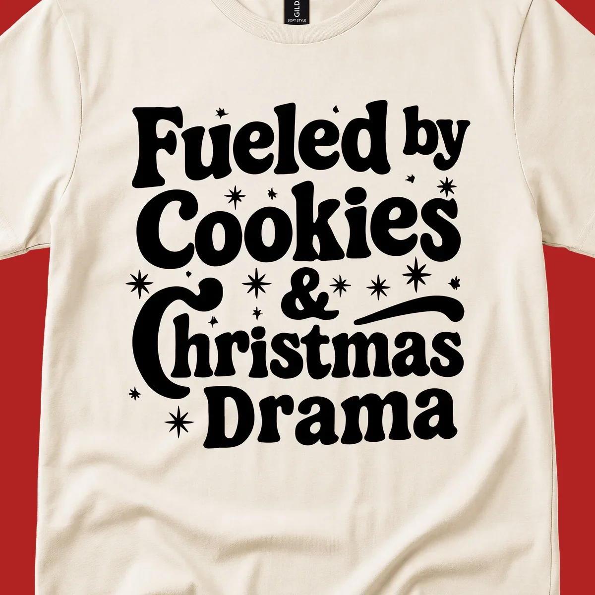 Text design 'Fueled by Cookies & Christmas Drama' with stars, for Christmas.