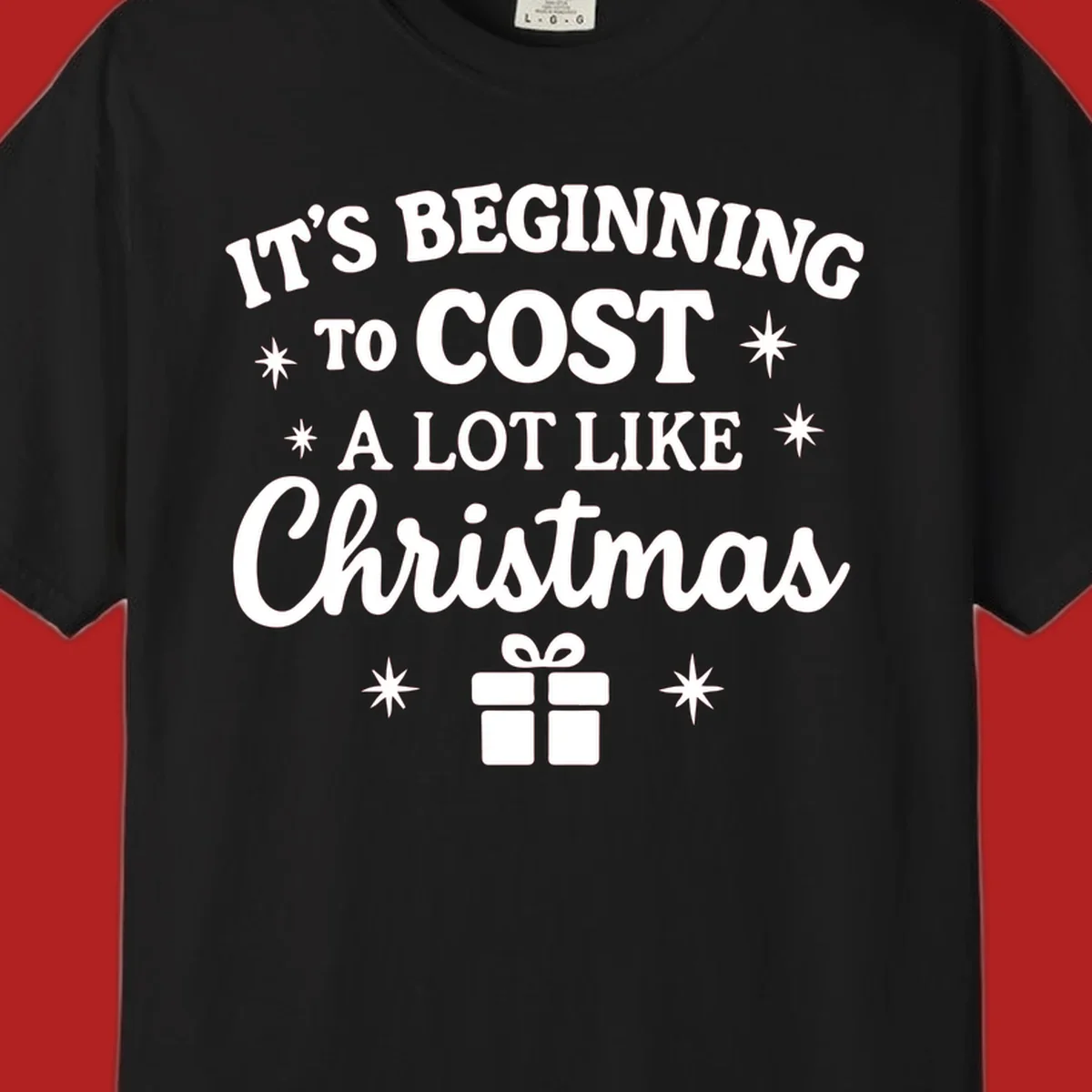 Typography design that says "It's Beginning To Cost A Lot Like Christmas" with stars and a gift box.