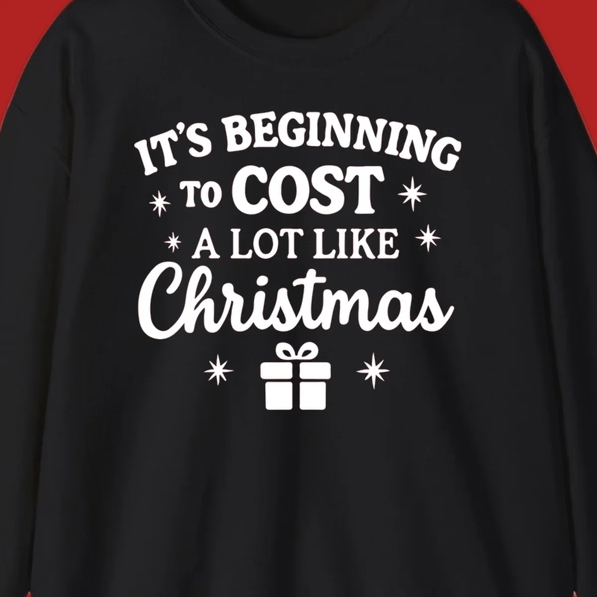 Typography design that says "It's Beginning To Cost A Lot Like Christmas" with stars and a gift box.