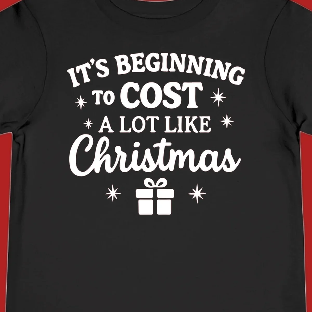 Typography design that says "It's Beginning To Cost A Lot Like Christmas" with stars and a gift box.