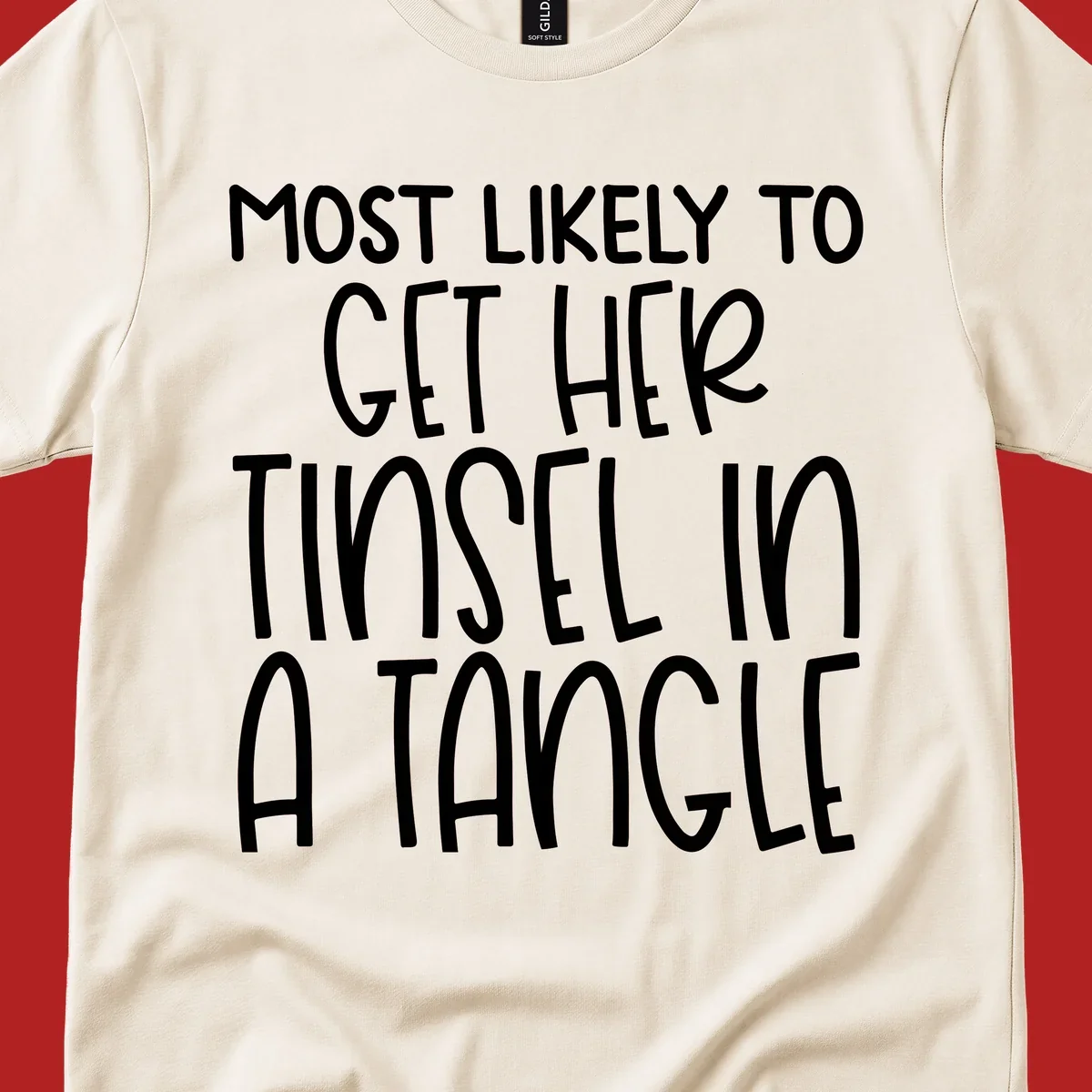 White text 'Most Likely To Get Her Tinsel In A Tangle' on a black background, holiday phrase.