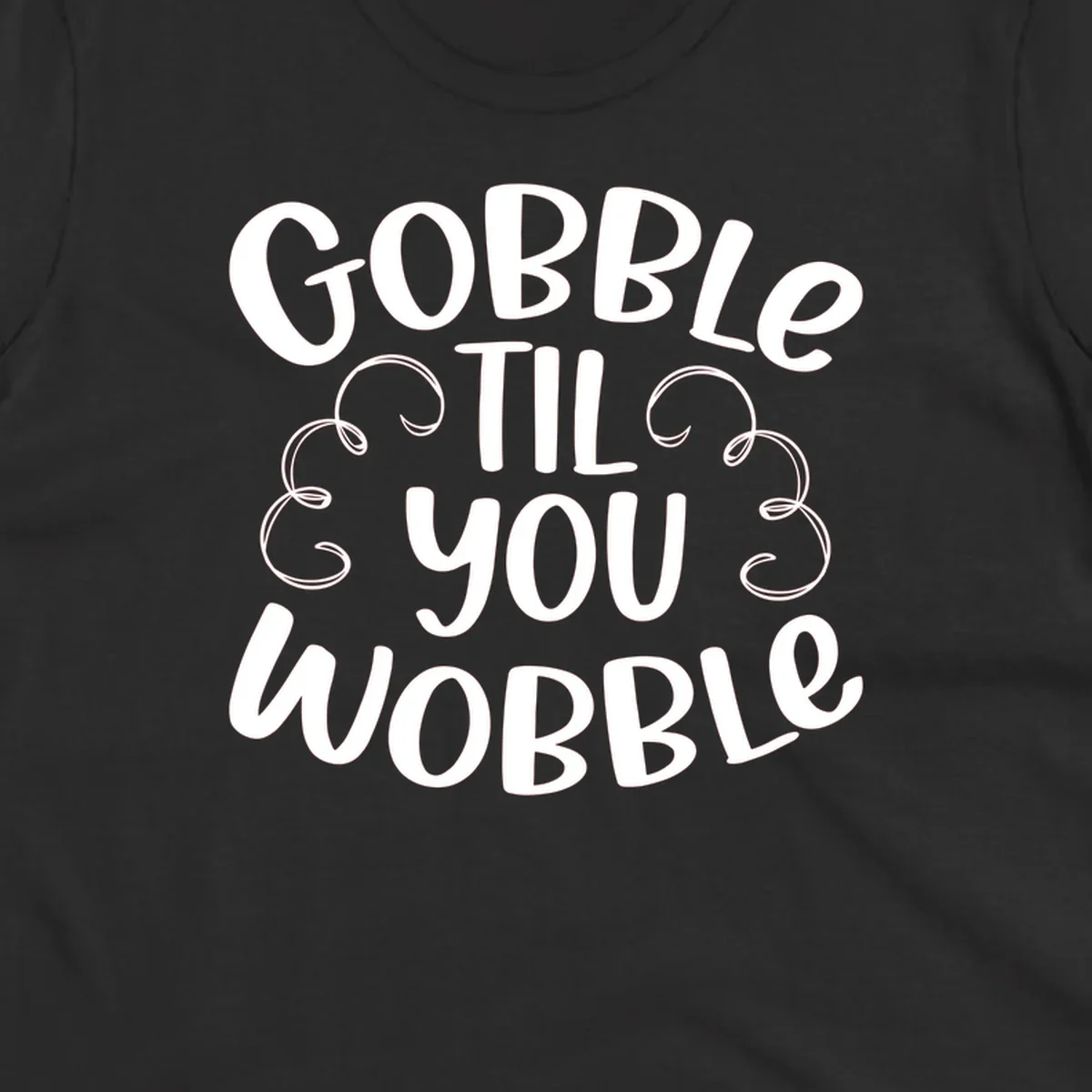 Gobble Til You Wobble Thanksgiving phrase in white text with decorative swirls.