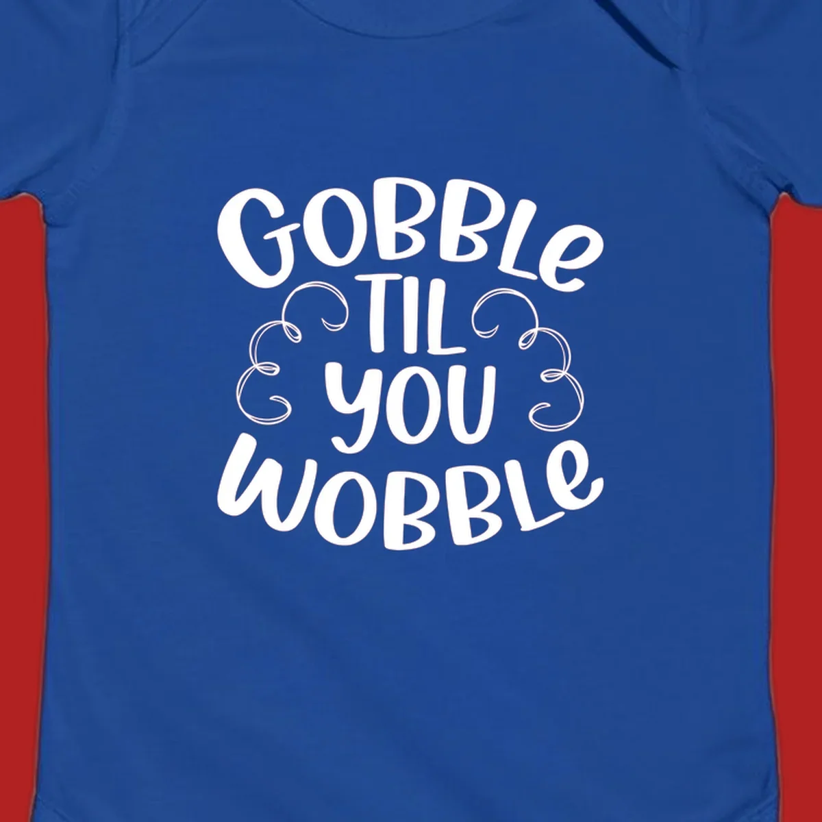 Gobble Til You Wobble Thanksgiving phrase in white text with decorative swirls.