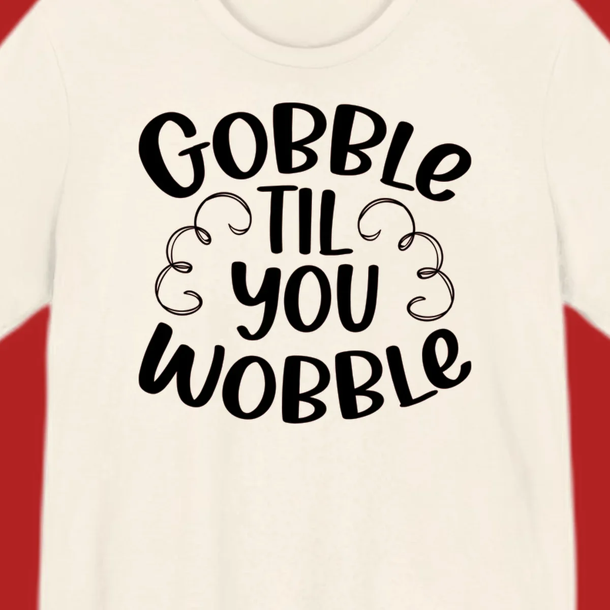 Gobble Til You Wobble Thanksgiving phrase in white text with decorative swirls.