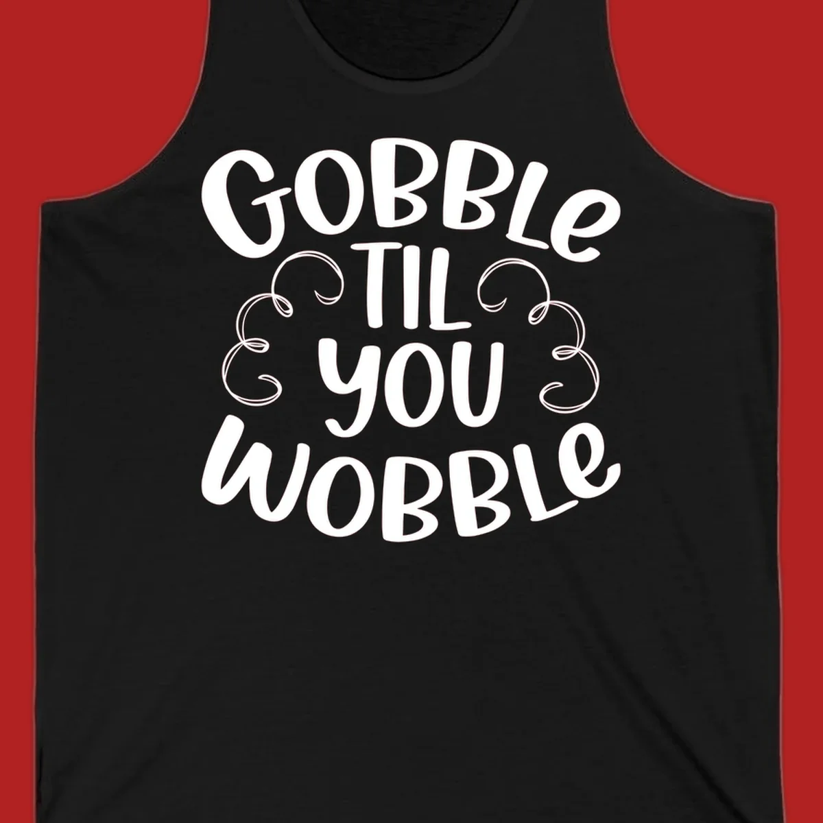 Gobble Til You Wobble Thanksgiving phrase in white text with decorative swirls.