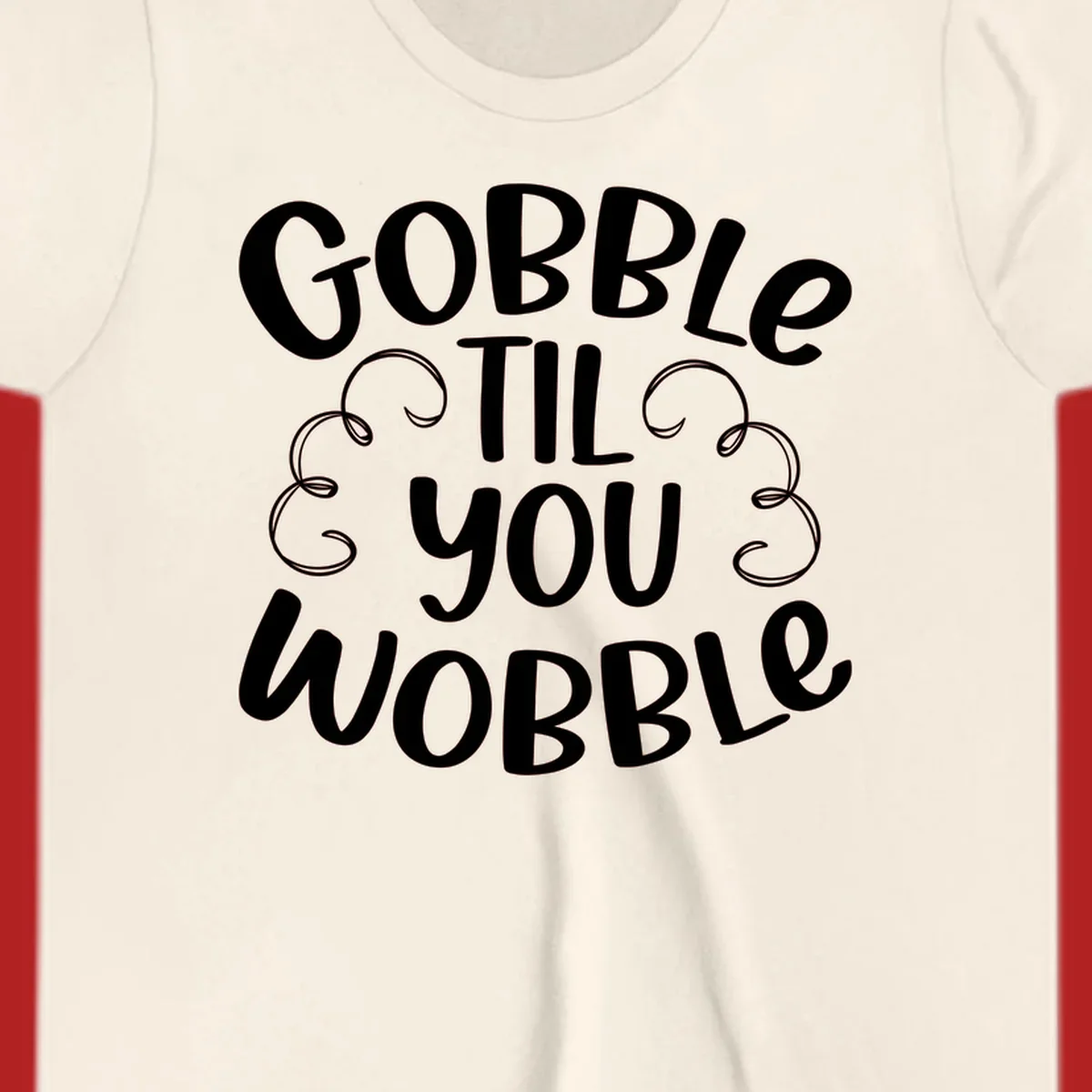 Gobble Til You Wobble Thanksgiving phrase in white text with decorative swirls.