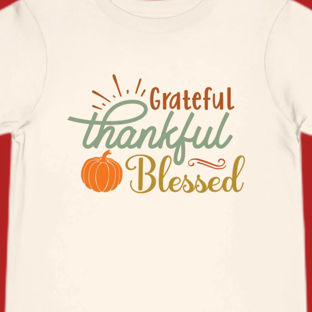 Grateful thankful blessed text with pumpkin and sun rays, autumn holiday design.