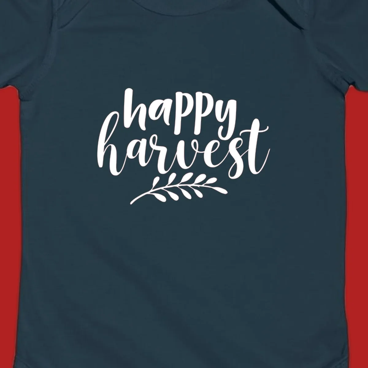 Happy harvest script text with a leaf sprig, suitable for fall and Thanksgiving.