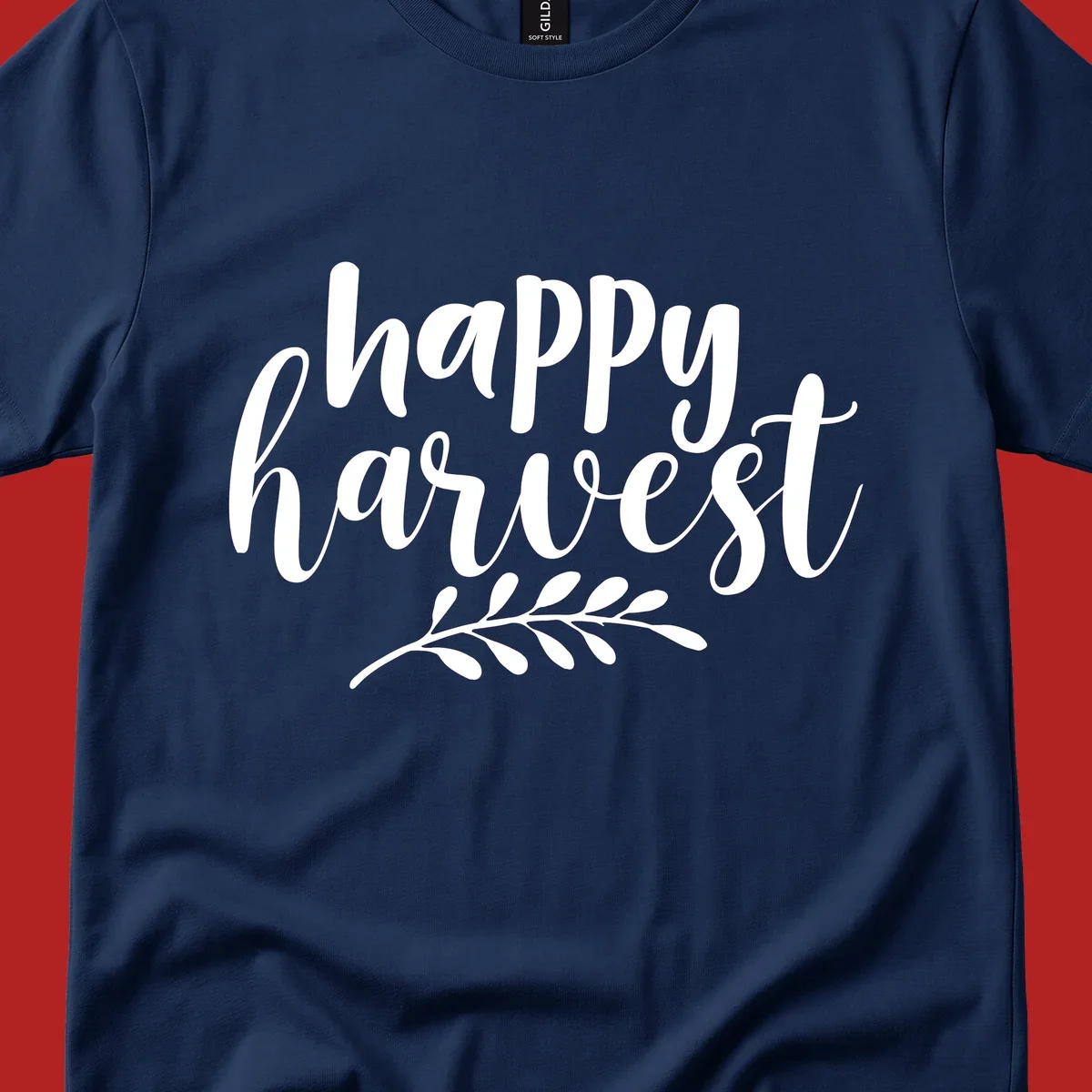Happy harvest script text with a leaf sprig, suitable for fall and Thanksgiving.