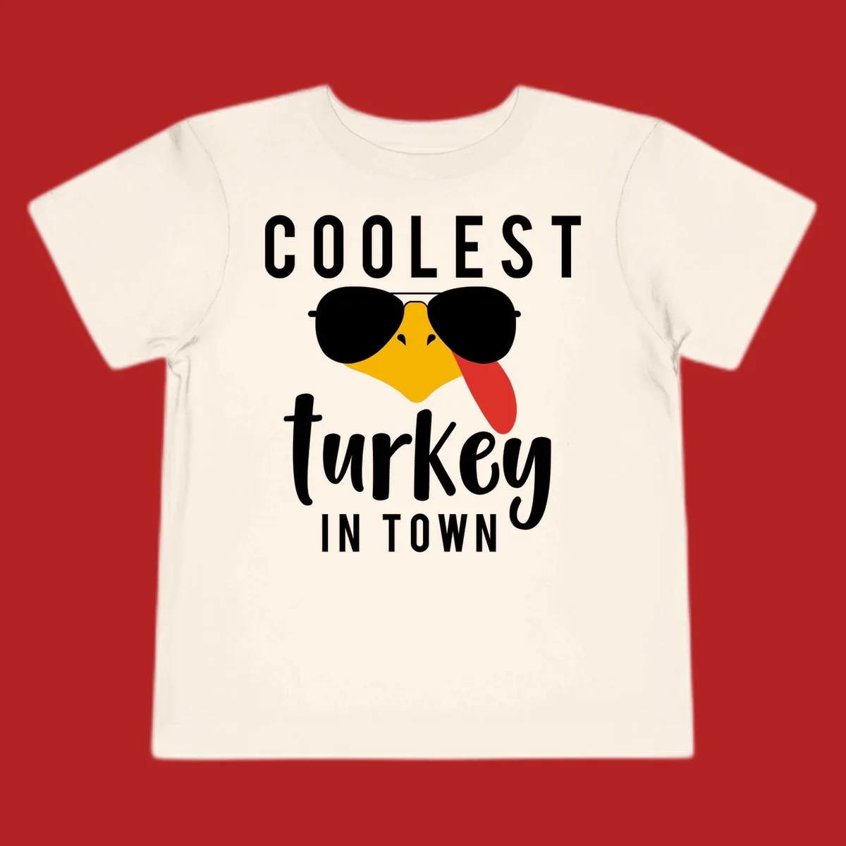 Coolest Turkey In Town Thanksgiving design with a cartoon turkey wearing sunglasses and sticking its tongue out.