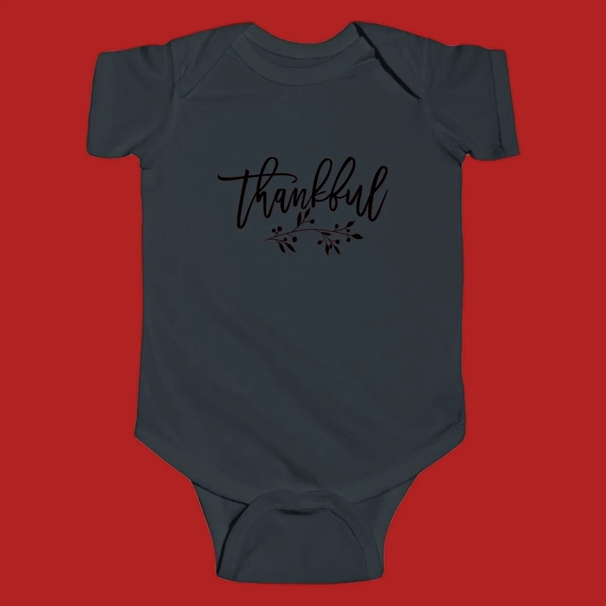 Elegant script text 'Thankful' with a small botanical branch accent, on a plain background.