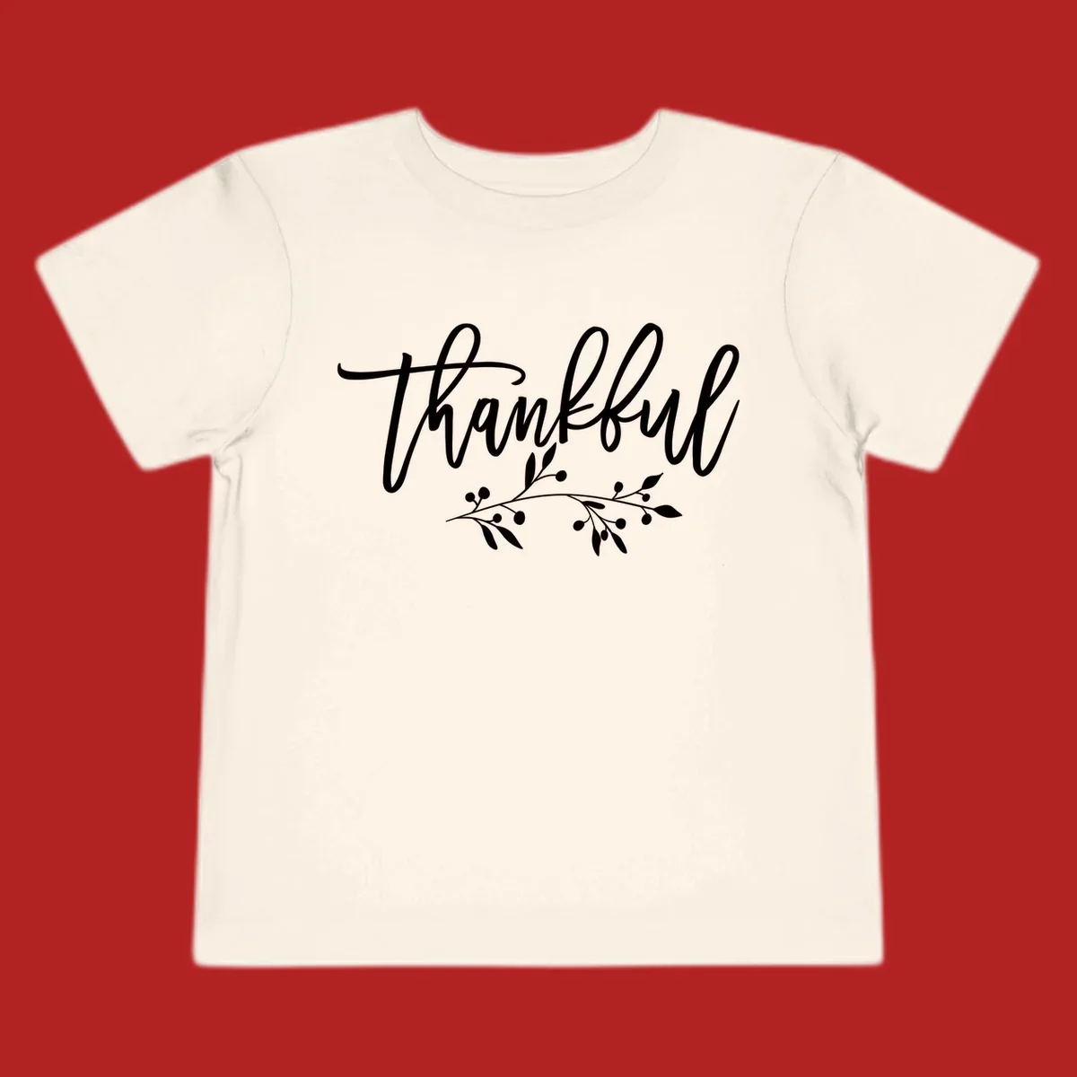 Elegant script text 'Thankful' with a small botanical branch accent, on a plain background.