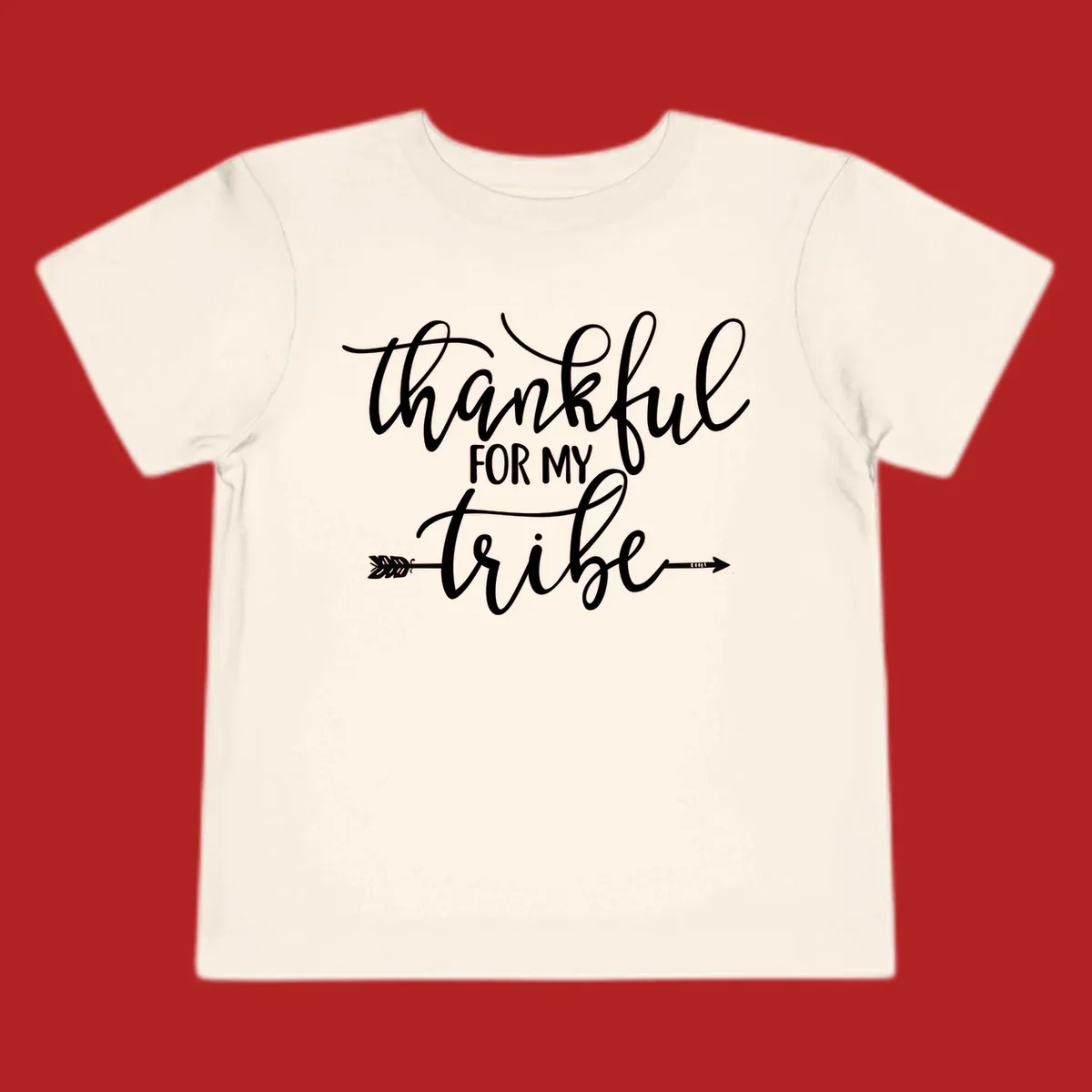 Thankful for my tribe typography design with arrow graphic on black background.