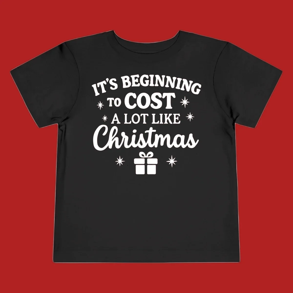 Typography design that says "It's Beginning To Cost A Lot Like Christmas" with stars and a gift box.
