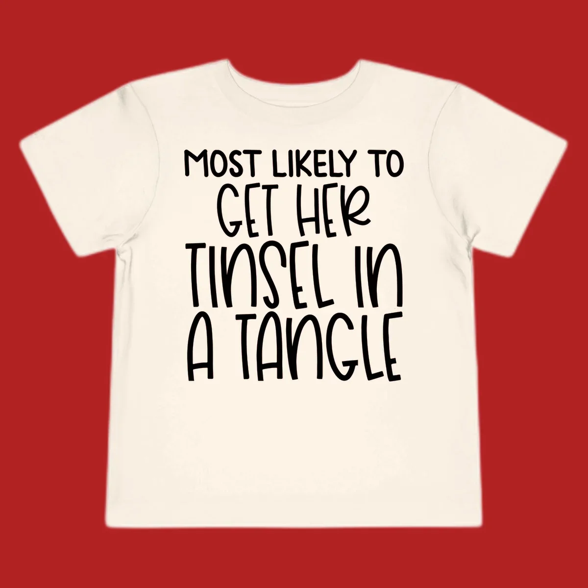 White text 'Most Likely To Get Her Tinsel In A Tangle' on a black background, holiday phrase.