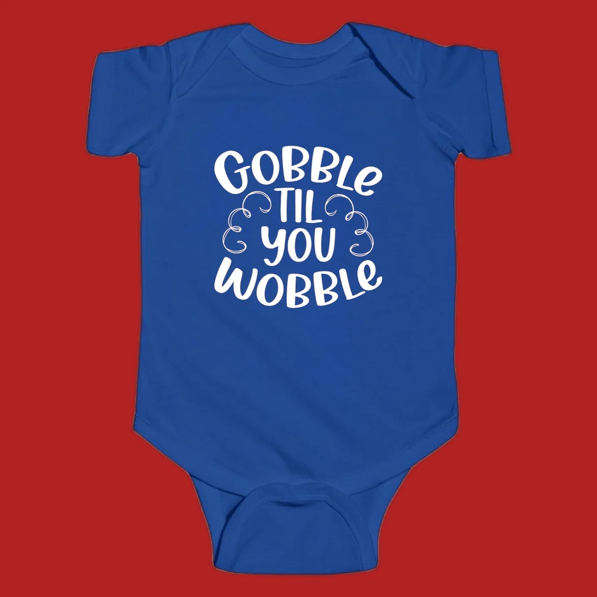Gobble Til You Wobble Thanksgiving phrase in white text with decorative swirls.