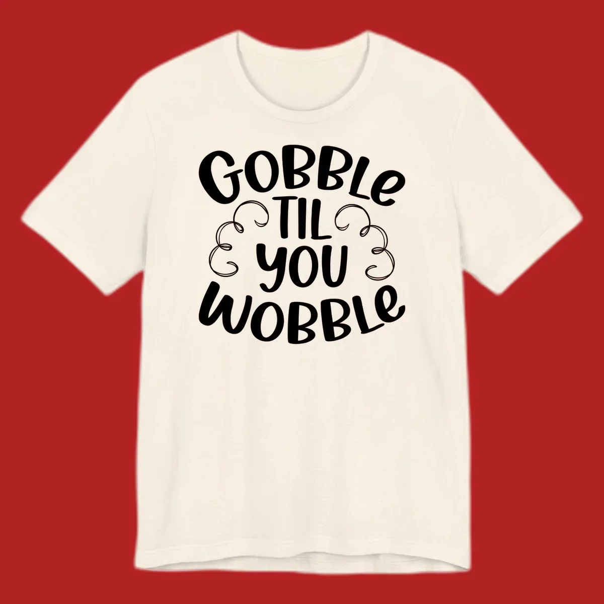 Gobble Til You Wobble Thanksgiving phrase in white text with decorative swirls.