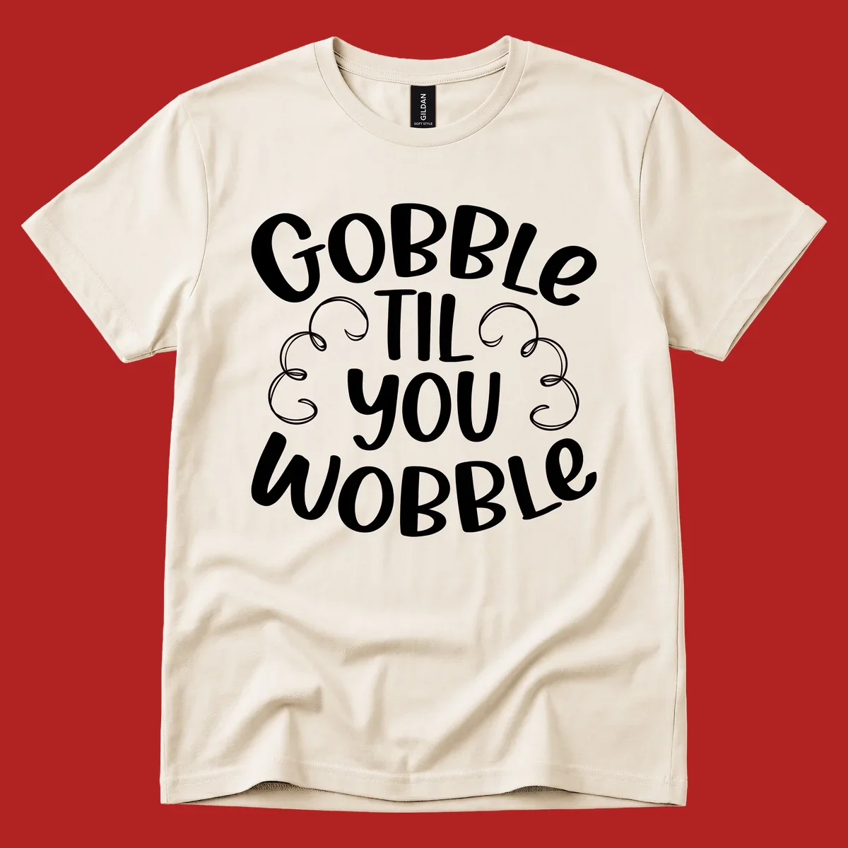 Gobble Til You Wobble Thanksgiving phrase in white text with decorative swirls.