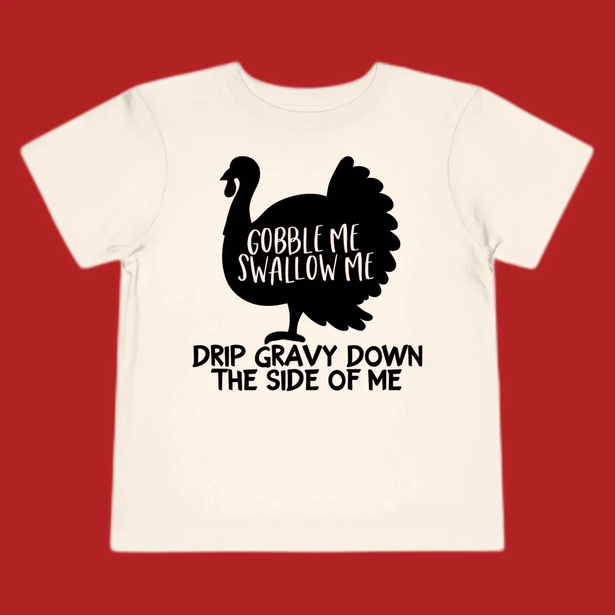 Thanksgiving turkey design with text, featuring a silhouette and the phrase 'Gobble Me Swallow Me Drip Gravy Down The Side Of Me'.