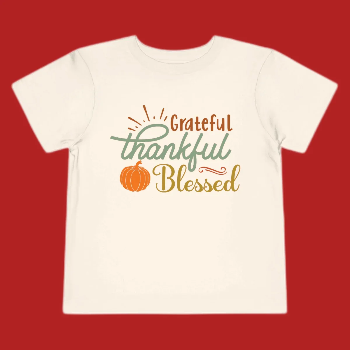Grateful thankful blessed text with pumpkin and sun rays, autumn holiday design.