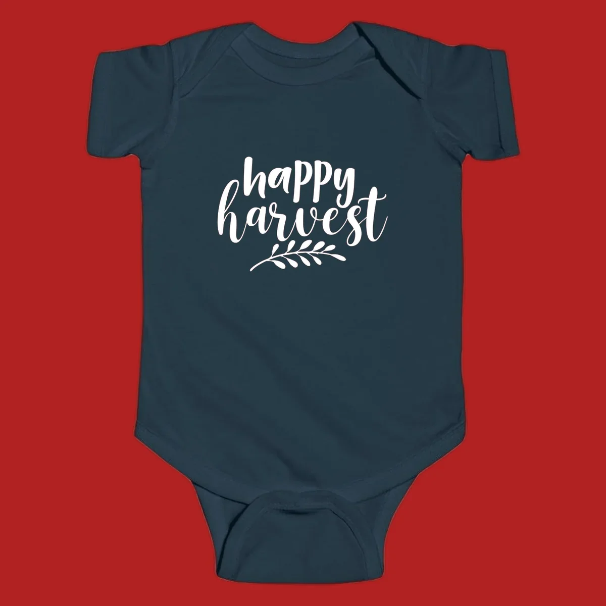 Happy harvest script text with a leaf sprig, suitable for fall and Thanksgiving.