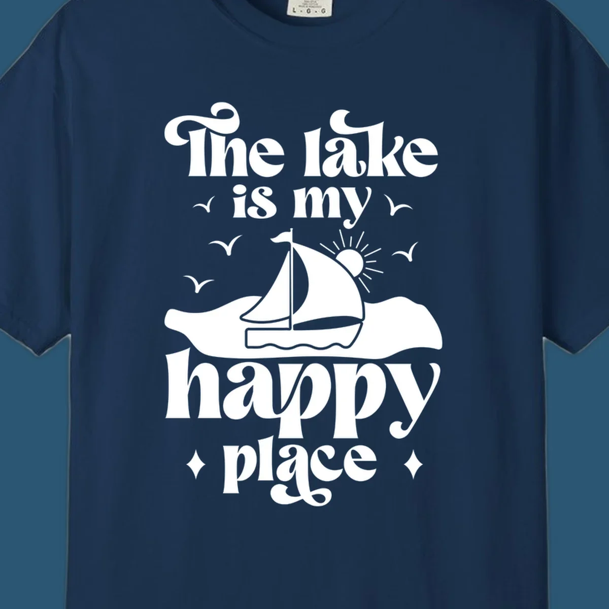 Retro text design 'The lake is my happy place' with sailboat, sun, and birds.