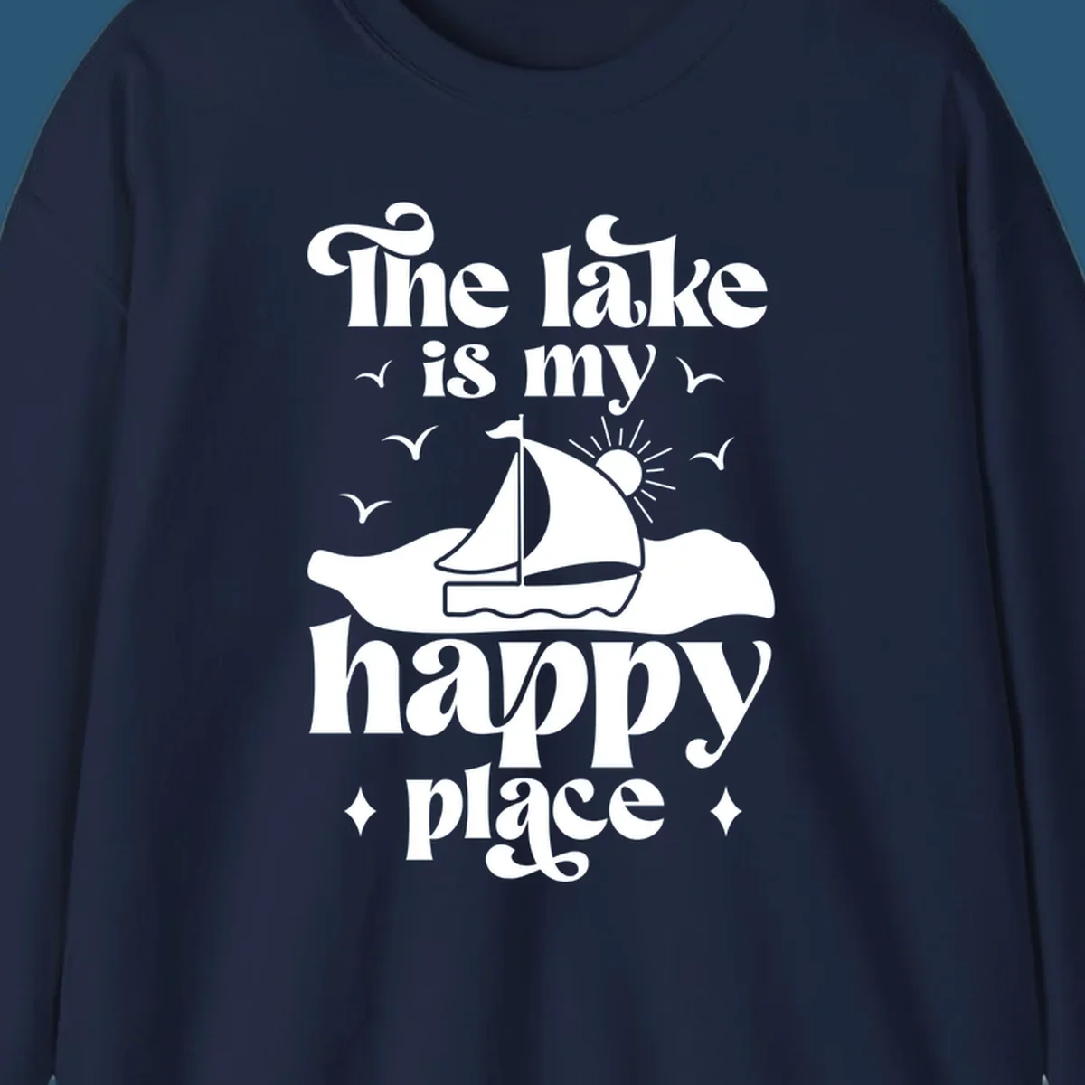 Retro text design 'The lake is my happy place' with sailboat, sun, and birds.