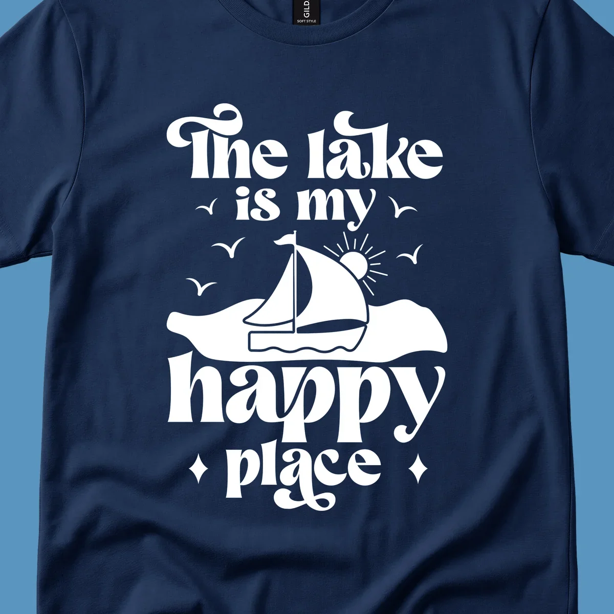Retro text design 'The lake is my happy place' with sailboat, sun, and birds.