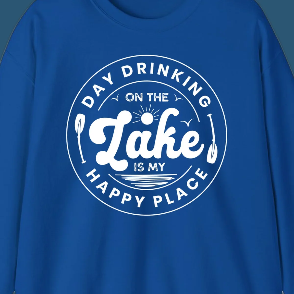 Circular badge design with text 'Day Drinking On The Lake Is My Happy Place' and lake-themed graphics.