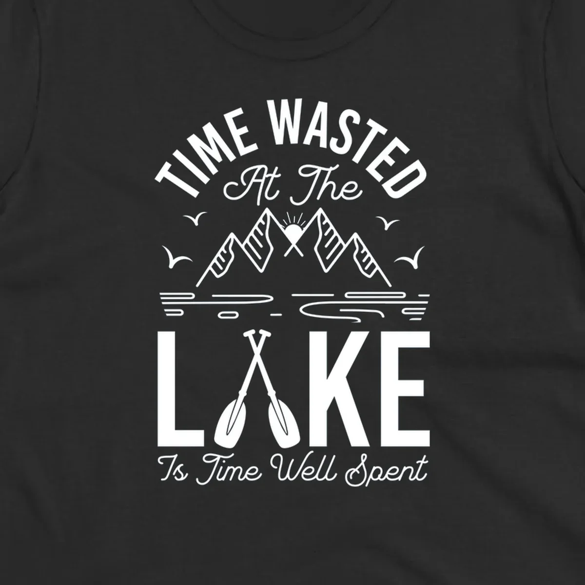Illustration of mountains, sun, birds, and oars with text 'Time Wasted At The Lake Is Time Well Spent'.