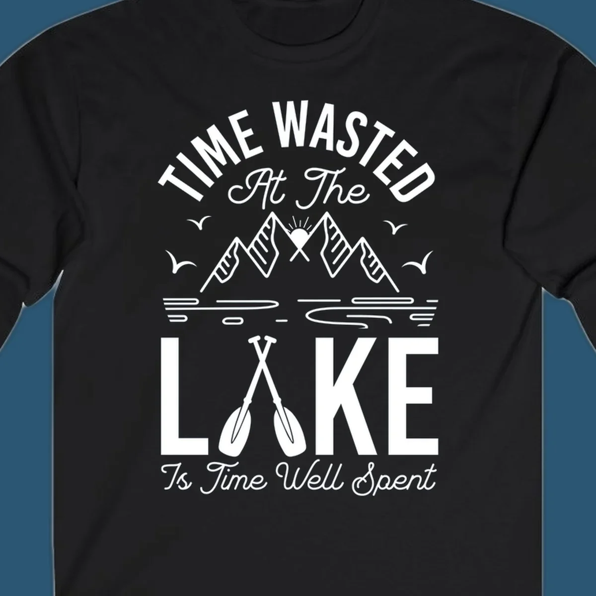 Illustration of mountains, sun, birds, and oars with text 'Time Wasted At The Lake Is Time Well Spent'.