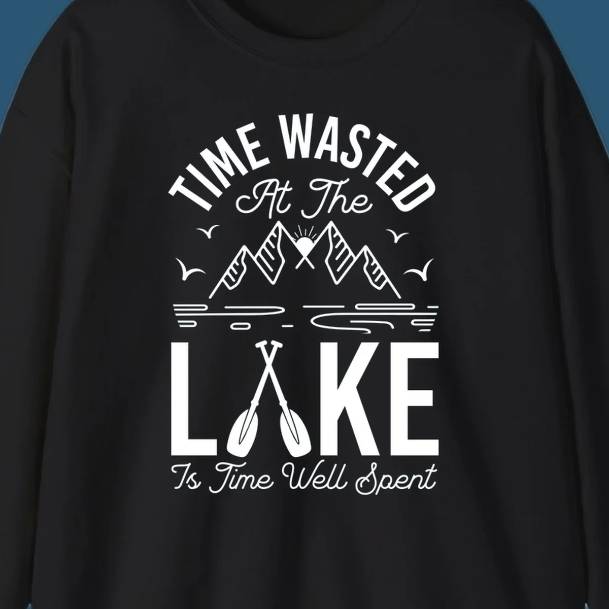 Illustration of mountains, sun, birds, and oars with text 'Time Wasted At The Lake Is Time Well Spent'.