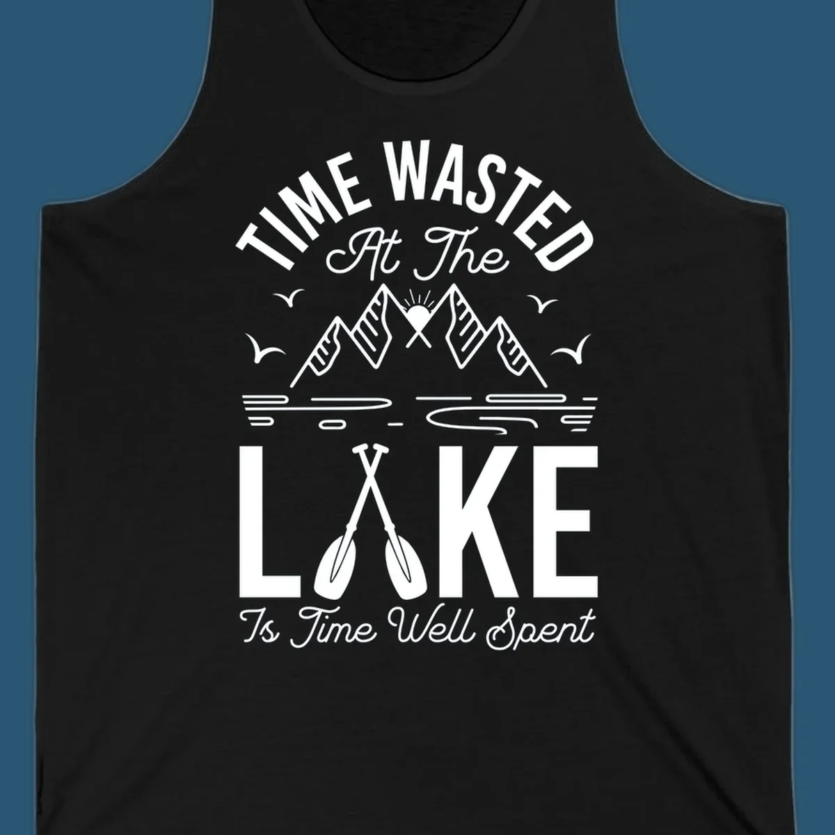 Illustration of mountains, sun, birds, and oars with text 'Time Wasted At The Lake Is Time Well Spent'.