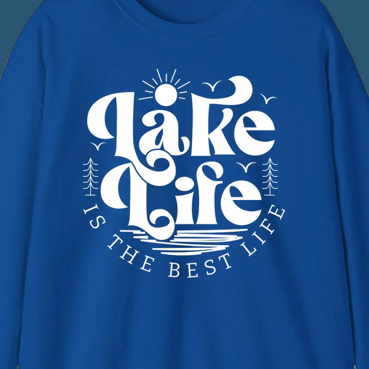 Lake life is the best life typography design with sun, birds, trees, and water elements.