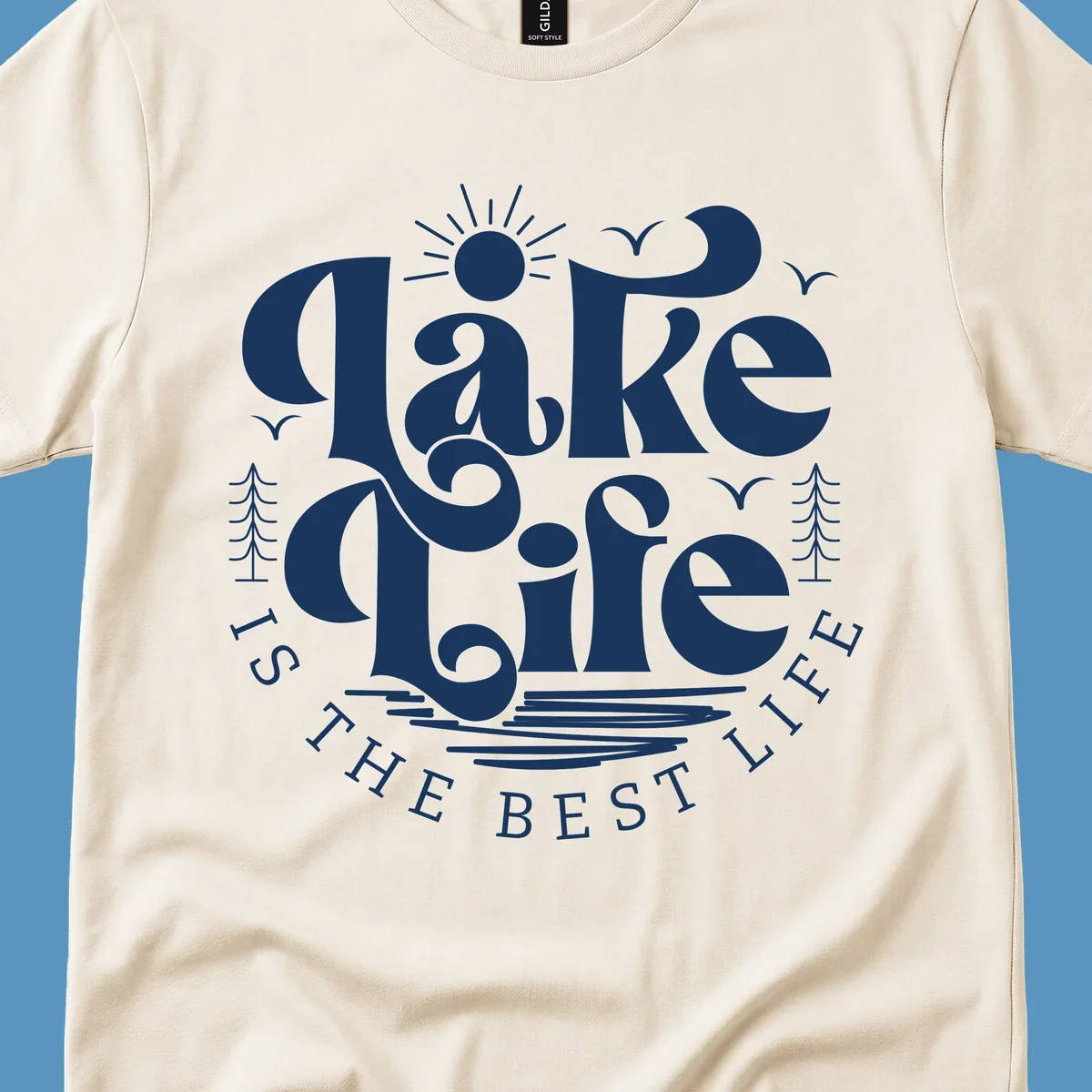 Lake life is the best life typography design with sun, birds, trees, and water elements.