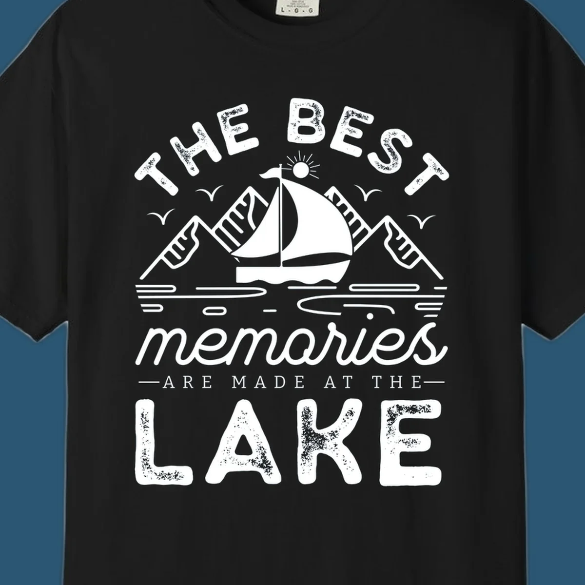 The Best Memories Are Made At The Lake design with mountains, sailboat, and text.