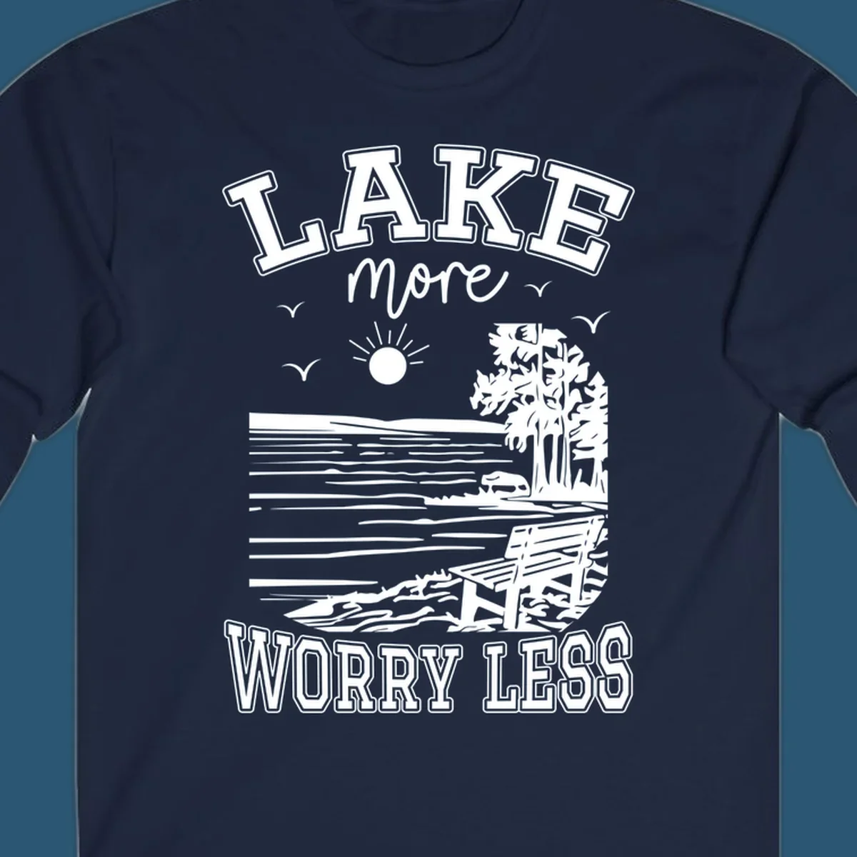 Lake More Worry Less scenic illustration with lake, trees, bench, and sun, white text on black, navy text on white.