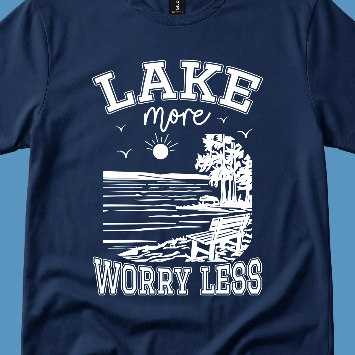 Lake More Worry Less scenic illustration with lake, trees, bench, and sun, white text on black, navy text on white.