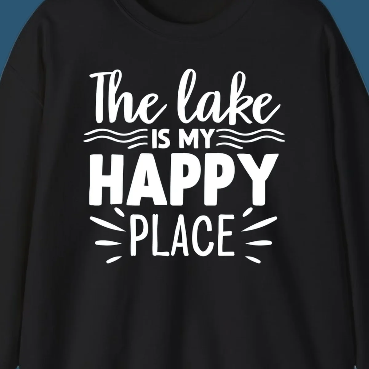 The lake is my happy place text design with wave and sun ray graphics.