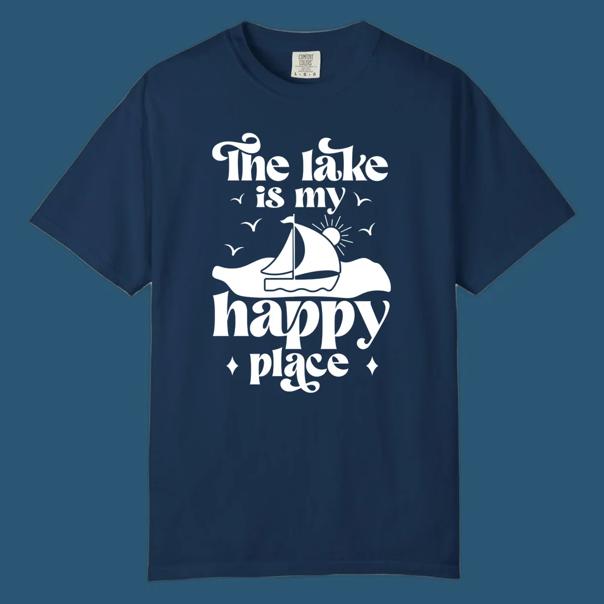 Retro text design 'The lake is my happy place' with sailboat, sun, and birds.