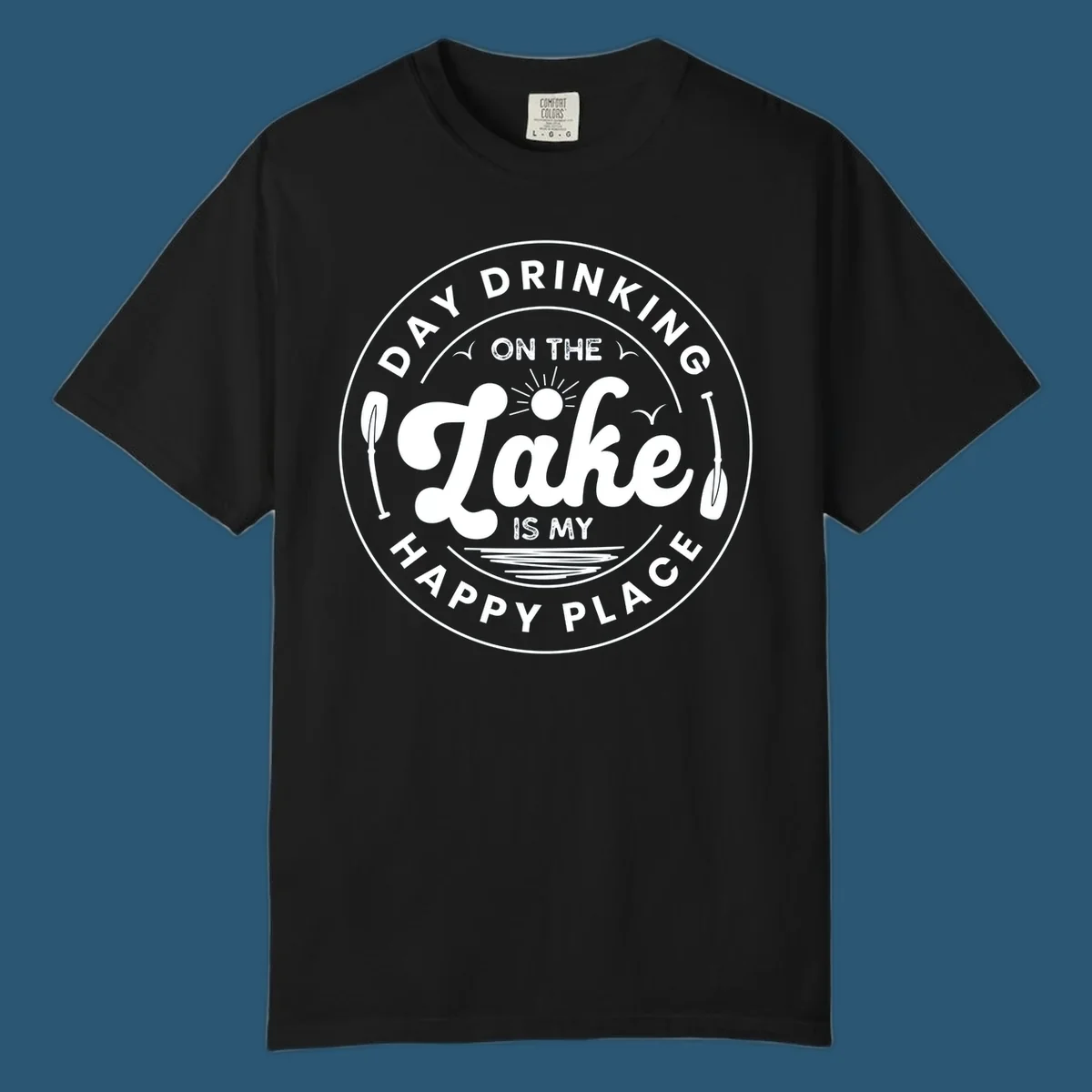 Circular badge design with text 'Day Drinking On The Lake Is My Happy Place' and lake-themed graphics.