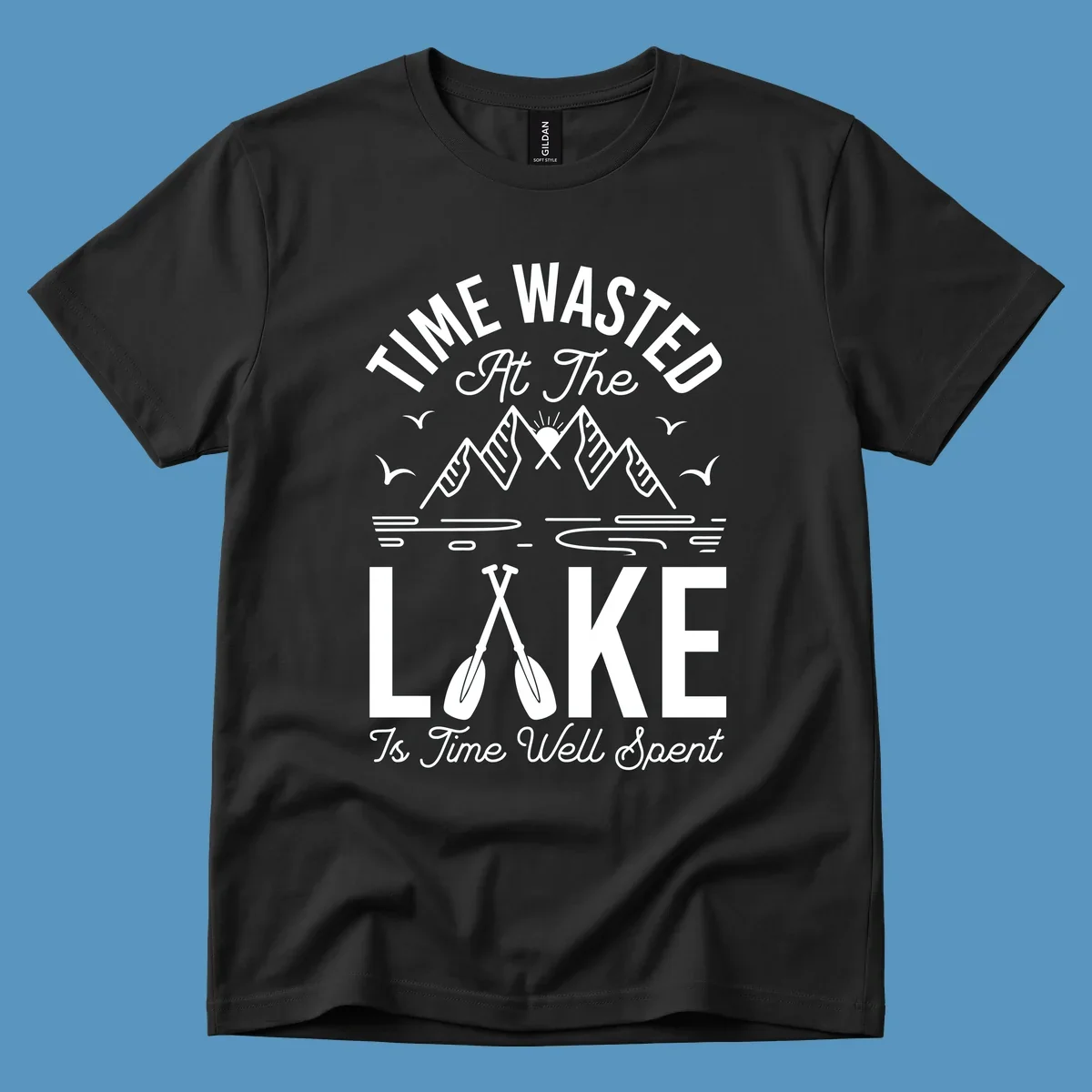 Illustration of mountains, sun, birds, and oars with text 'Time Wasted At The Lake Is Time Well Spent'.