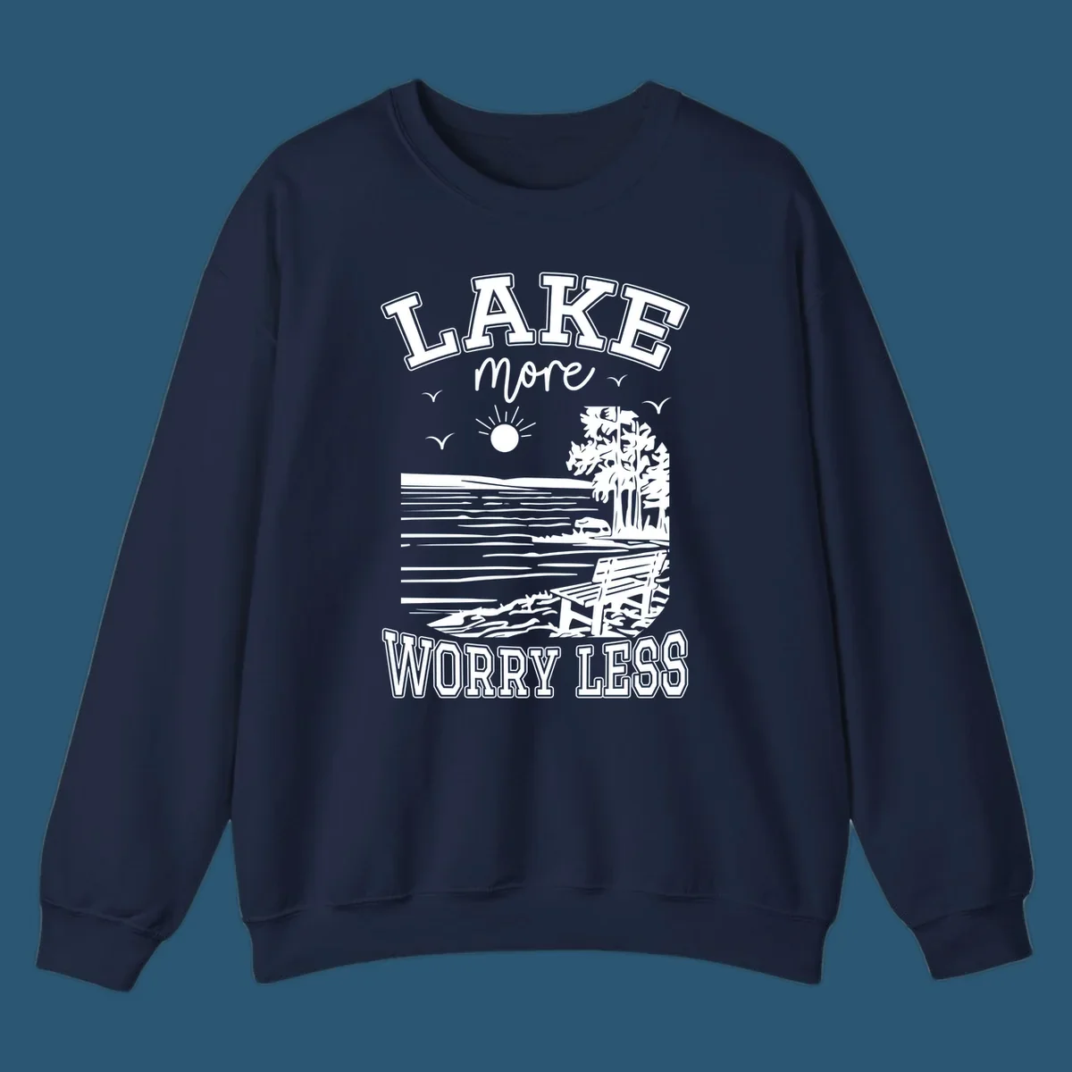 Lake More Worry Less scenic illustration with lake, trees, bench, and sun, white text on black, navy text on white.